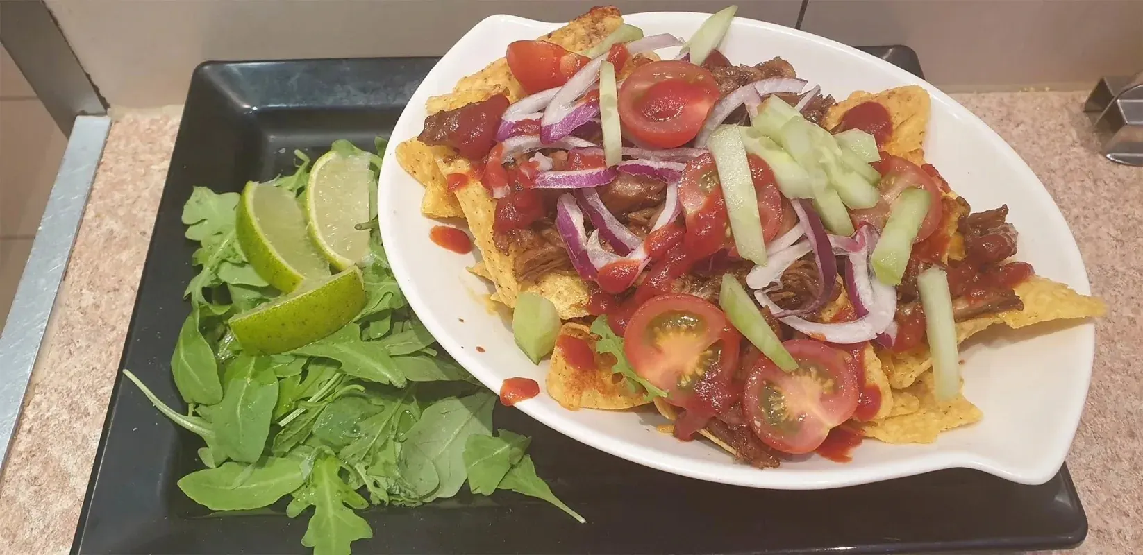 Nacho's met pulled pork, tomaat, rode ui en komkommer